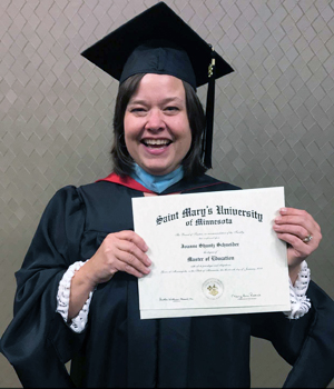 This a photo of Joanne Schneider with her diploma during her commencement ceremony.